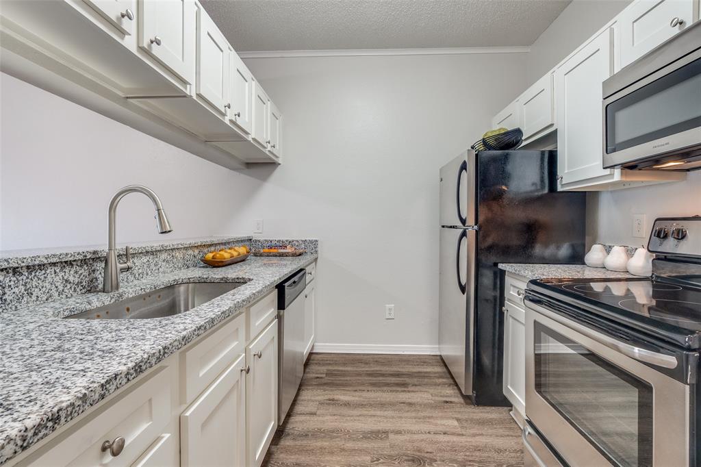 6003 Oram Street, Unit 107 Dallas, TX 75206 - Photo 6 of 23 a kitchen with stainless steel appliances granite countertop a sink and a stove