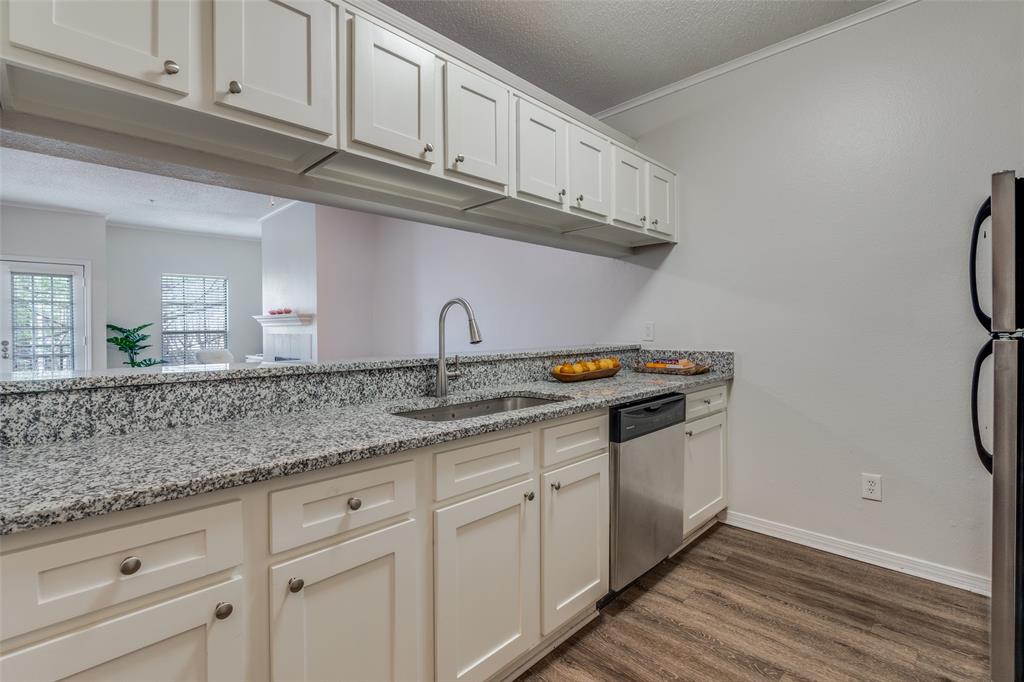 6003 Oram Street, Unit 107 Dallas, TX 75206 - Photo 7 of 23 a kitchen with stainless steel appliances granite countertop a sink and cabinets