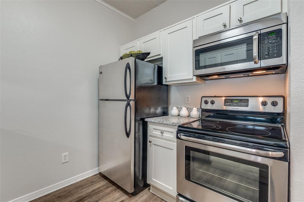 6003 Oram Street, Unit 107 Dallas, TX 75206 - Photo 8 of 23 a kitchen with stainless steel appliances a stove microwave and refrigerator