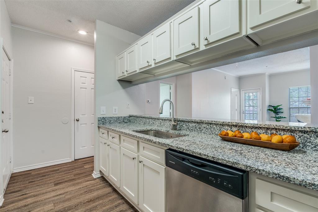 6003 Oram Street, Unit 107 Dallas, TX 75206 - Photo 9 of 23 a kitchen with stainless steel appliances granite countertop a sink and cabinets