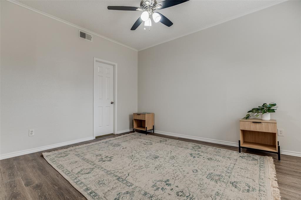 6003 Oram Street, Unit 107 Dallas, TX 75206 - Photo 10 of 23 an empty room with a chandelier fan and wooden floor
