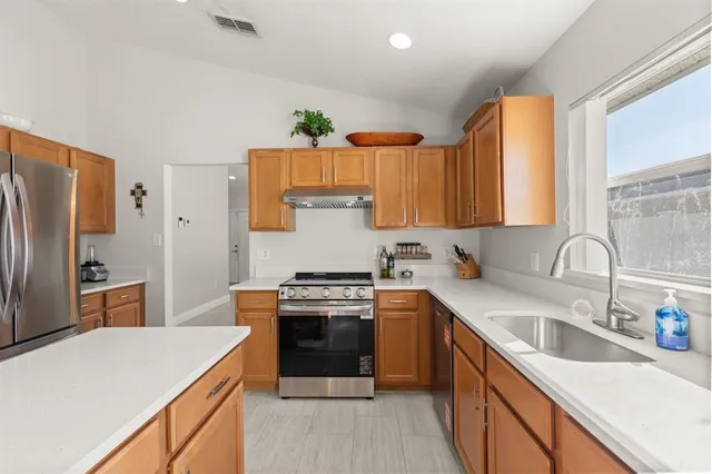 a kitchen with stainless steel appliances granite countertop a sink stove and refrigerator