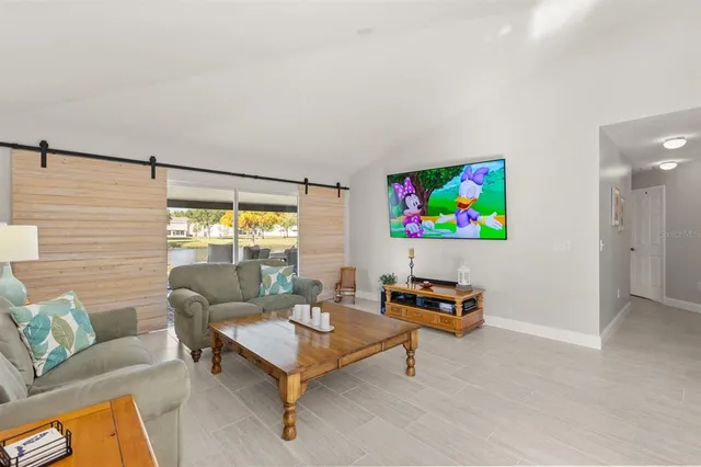 a living room with furniture and view of kitchen