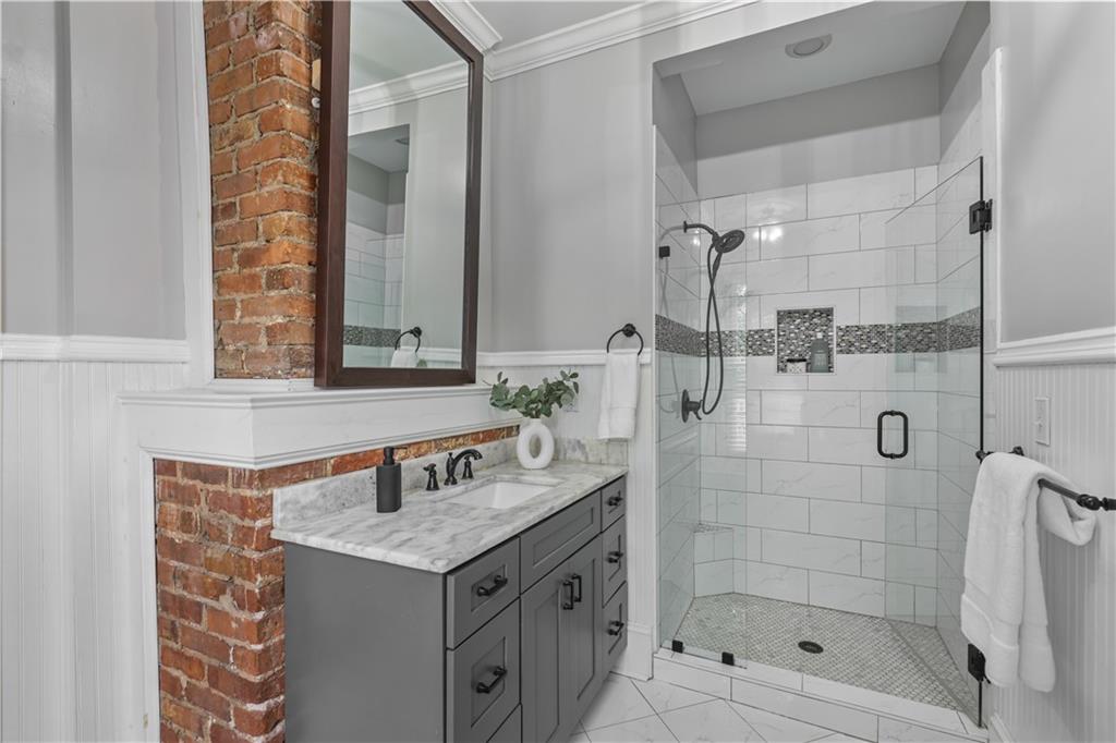 2891 Macaw Street Northwest Atlanta, GA 30318 - Photo 18 of 26 a bathroom with a granite countertop sink a mirror and shower