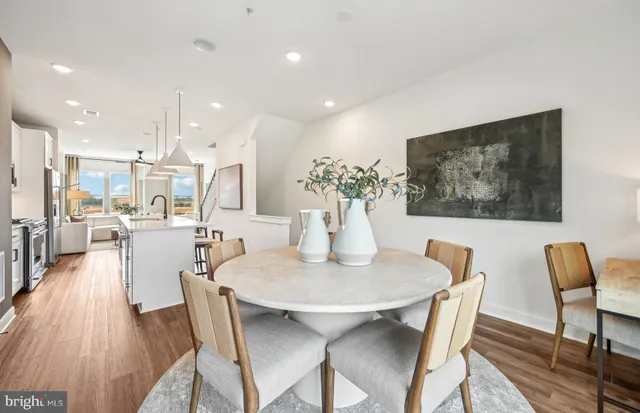 a kitchen with stainless steel appliances granite countertop a sink a stove and a wooden floors