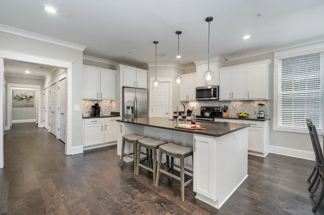 a kitchen with kitchen island granite countertop a sink cabinets and stainless steel appliances