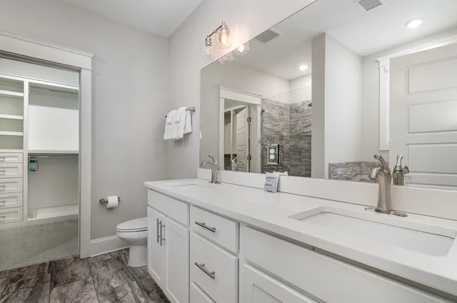 a bathroom with a sink and mirror with toilet
