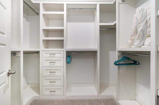 a view of walk in closet with empty racks