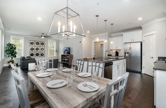 a kitchen with stainless steel appliances kitchen island granite countertop a dining table and chairs