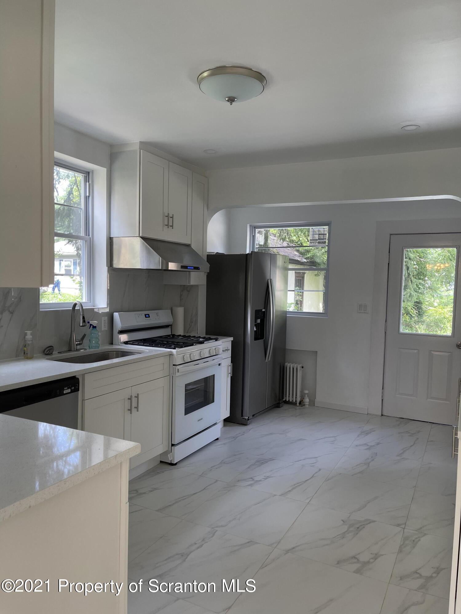 9 Front Street Clarks Summit, PA 18411 - Photo 13 of 22 a kitchen with granite countertop a refrigerator stove top oven and sink
