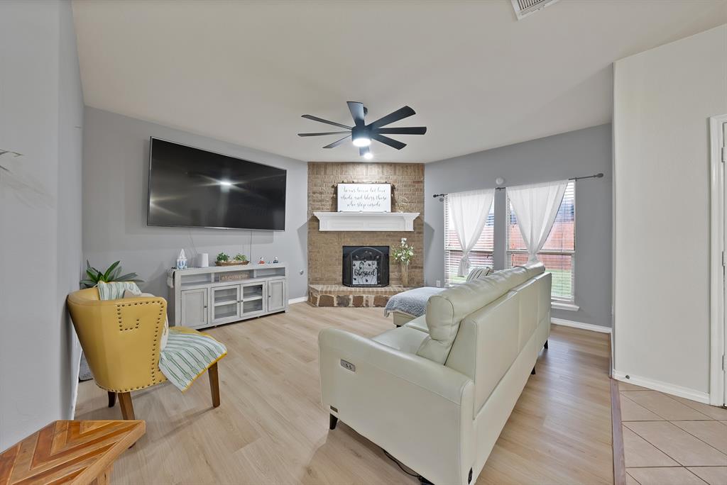 3822 Spring Run Lane Melissa, TX 75454 - Photo 10 of 39 a living room with furniture a fireplace and a flat screen tv