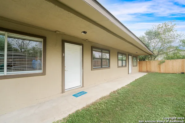 a view of house with backyard and front door