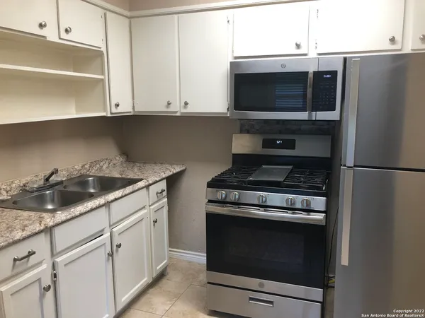 a kitchen with granite countertop a stove and a microwave