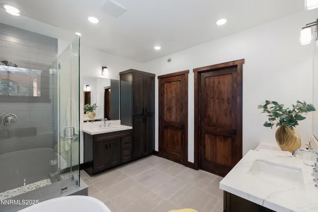 a spacious bathroom with a granite countertop sink a toilet a mirror and shower