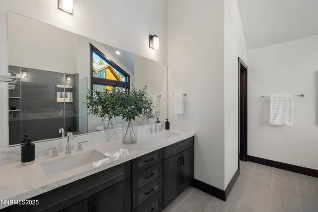 a bathroom with a double vanity sink a mirror and a shower