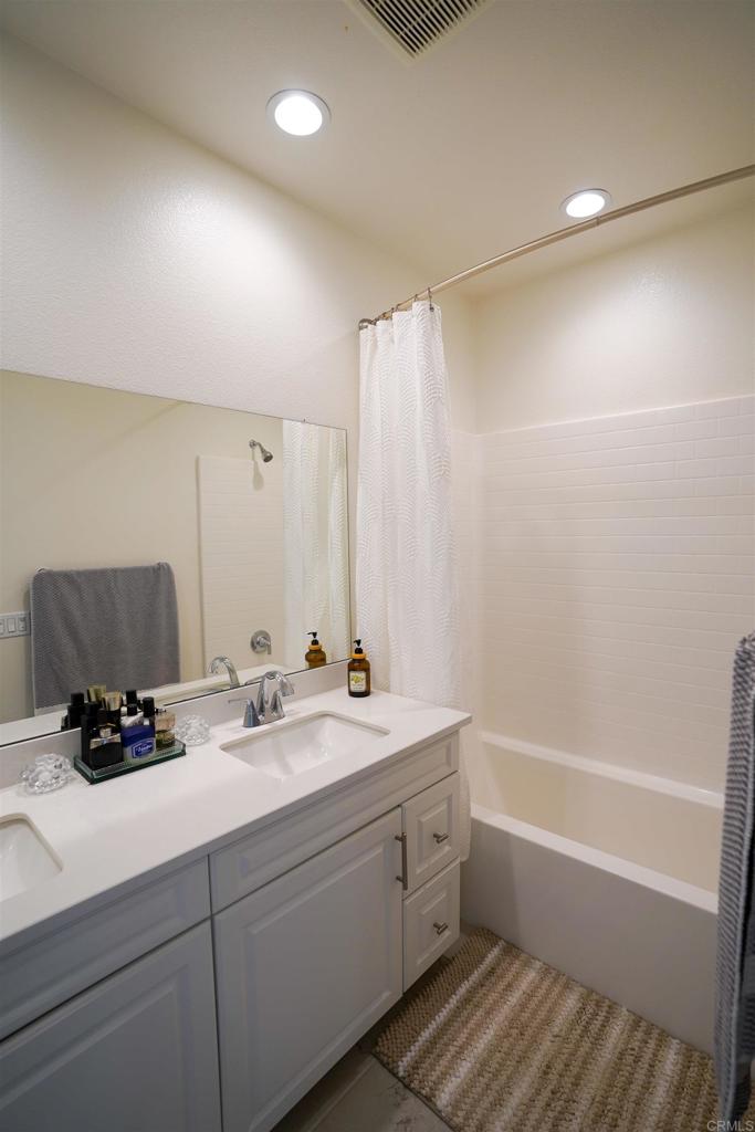 8375 Tahoe Street Lemon Grove, CA 91945 - Photo 16 of 27 a bathroom with a double vanity sink a mirror and a bathtub