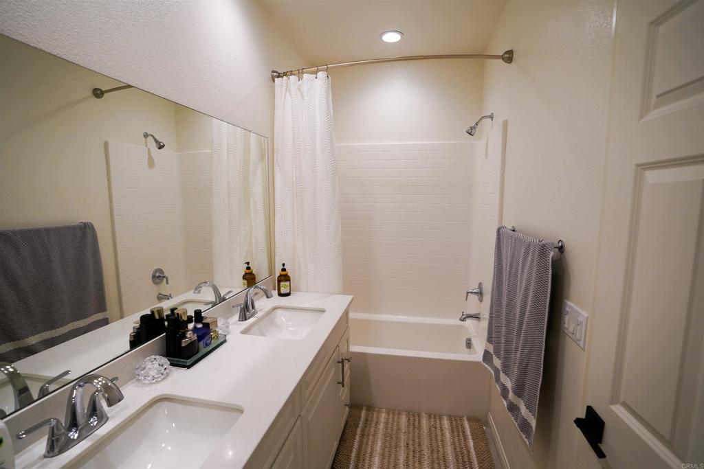 8375 Tahoe Street Lemon Grove, CA 91945 - Photo 17 of 27 a bathroom with a double vanity sink a mirror and a shower