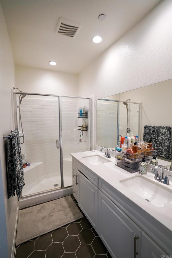 8375 Tahoe Street Lemon Grove, CA 91945 - Photo 22 of 27 a bathroom with a double vanity sink a mirror and a shower