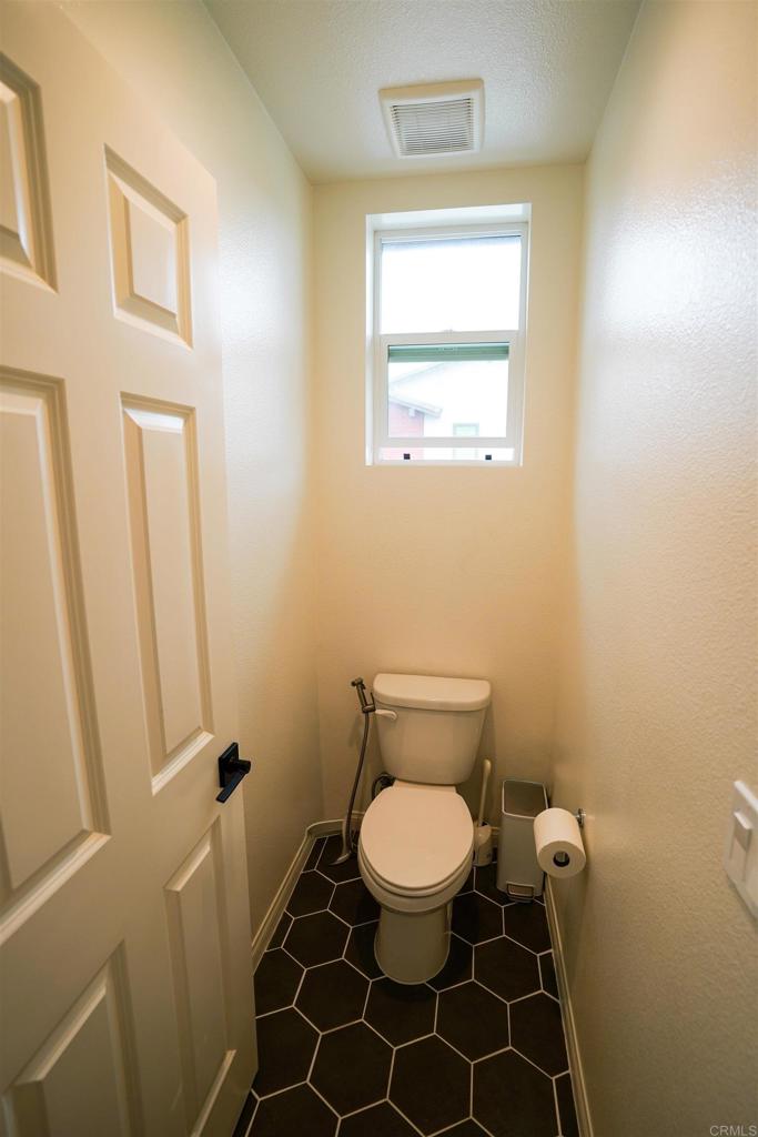 8375 Tahoe Street Lemon Grove, CA 91945 - Photo 24 of 27 a white toilet sitting next to a bathroom sink and a mirror