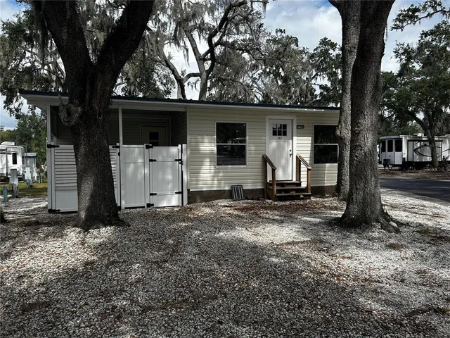 a view of a house with a tree in the forest