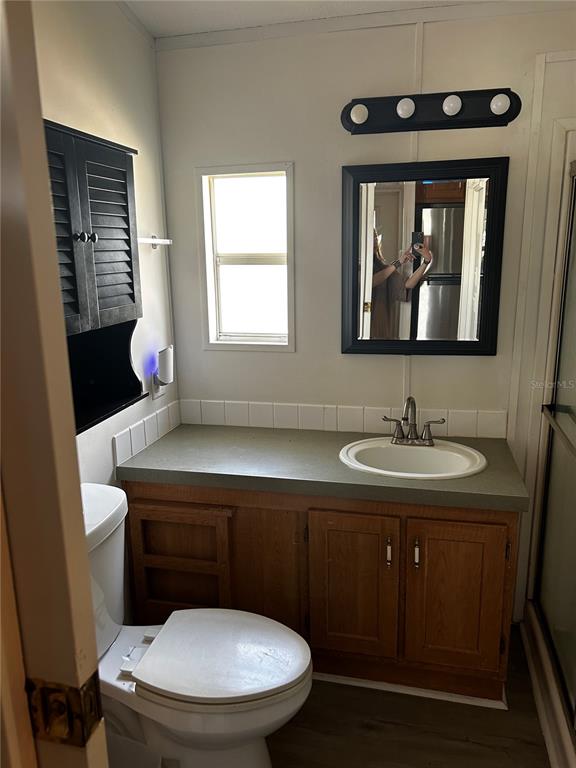6946 Old Pasco Road, Unit LOT 1 Wesley Chapel, FL 33544 - Photo 13 of 16 a bathroom with a toilet sink and mirror