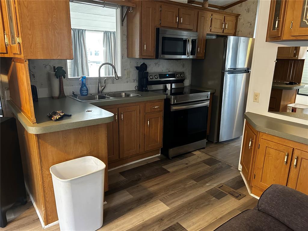 6946 Old Pasco Road, Unit LOT 1 Wesley Chapel, FL 33544 - Photo 8 of 16 a kitchen with stainless steel appliances granite countertop a refrigerator a stove top oven a sink and dishwasher