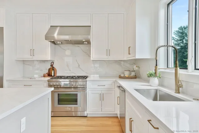 a kitchen with appliances a sink and cabinets