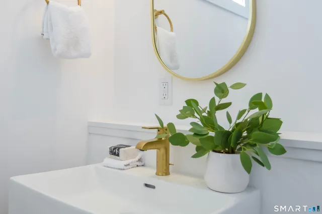 a white vase with white and yellow flowers