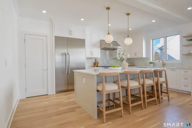 a kitchen with a dining table chairs sink and cabinets
