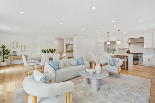 a living room with furniture and a dining table with kitchen view