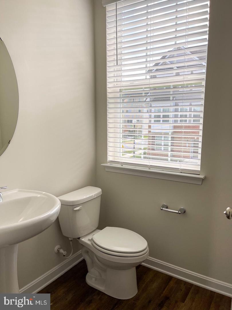 7066 Delegate Place Frederick, MD 21703 - Photo 14 of 25 a white toilet sitting next to a bathroom sink and vanity