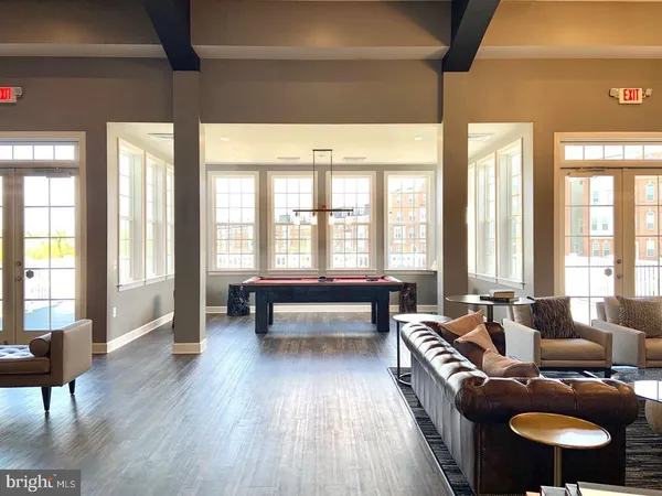 a living room with furniture a wooden floor and kitchen view