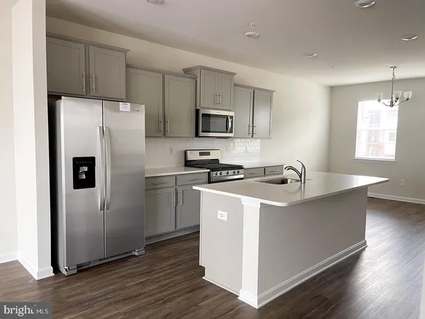 a kitchen with stainless steel appliances granite countertop a sink stove and wooden floor