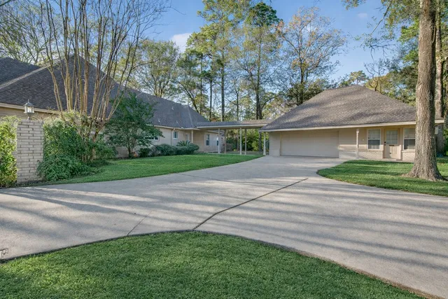 a front view of a house with a garden and trees