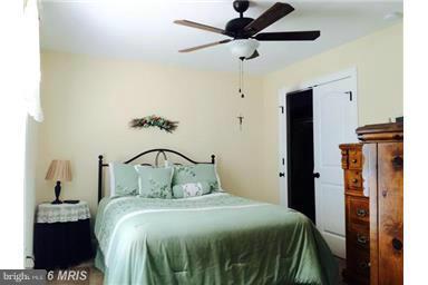 28 Job Road Inwood, WV 25428 - Photo 7 of 15 a bedroom with a bed and a chandelier