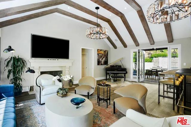 a living room with furniture a flat screen tv and floor to ceiling window