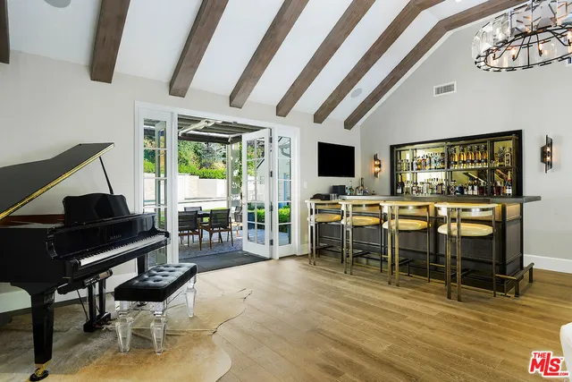a living room with furniture a flat screen tv and a floor to ceiling window