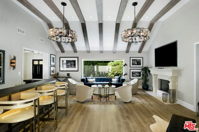 a view of a dining room with furniture a chandelier and wooden floor