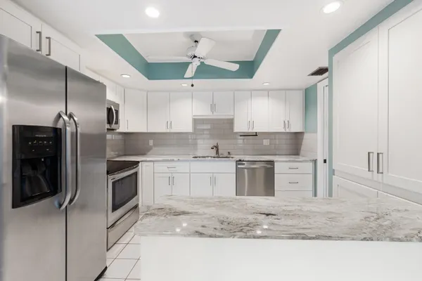 a kitchen with stainless steel appliances granite countertop a sink a stove and a refrigerator