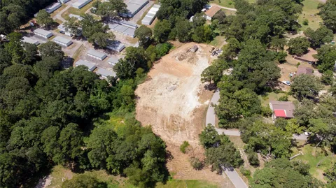 an aerial view of residential house with parking and trees