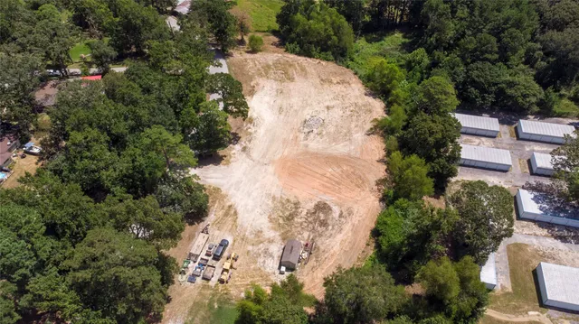an aerial view of a house with a yard and large trees