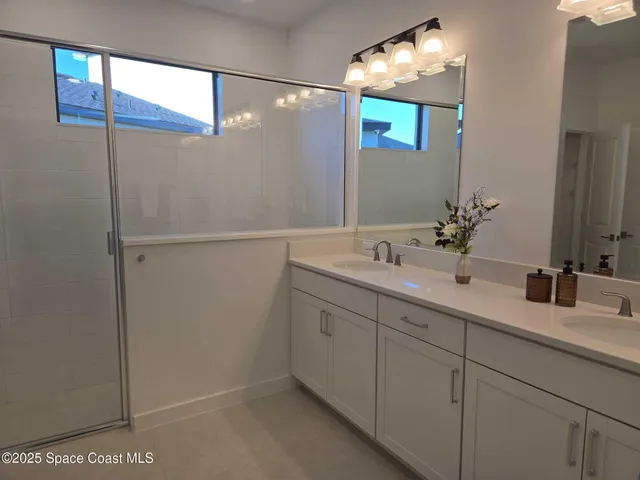 a bathroom with a double vanity sink and a mirror