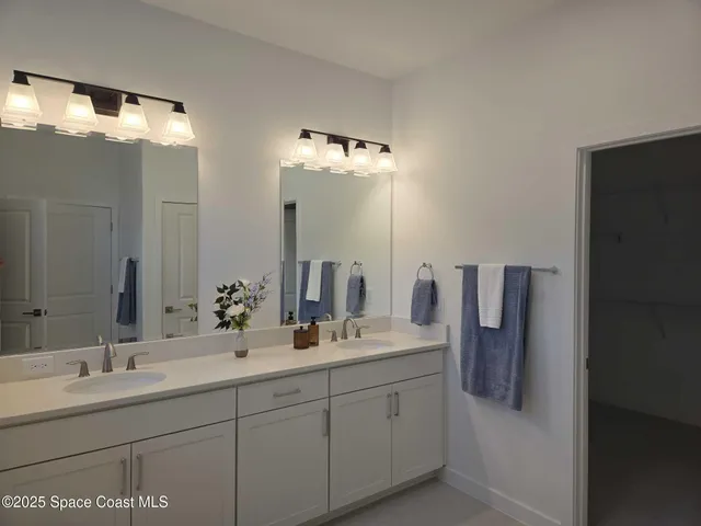 a bathroom with a double vanity sink and a mirror