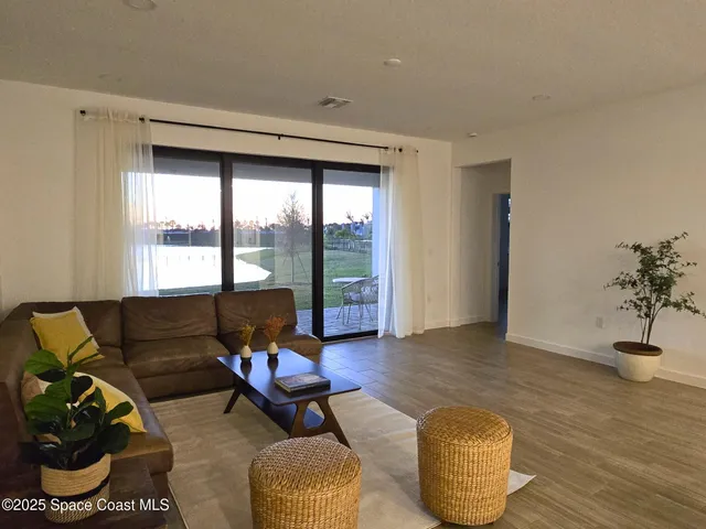 a living room with furniture and a floor to ceiling window