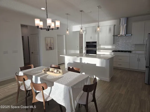 a kitchen with granite countertop white cabinets and stainless steel appliances