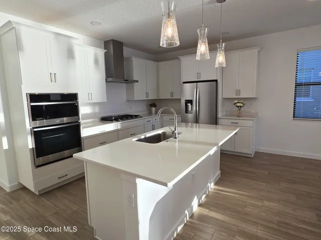 a kitchen with stainless steel appliances a sink and a refrigerator