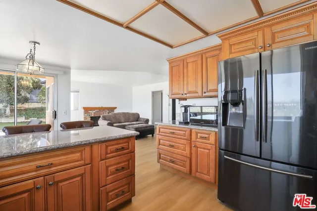 a kitchen with stainless steel appliances granite countertop a refrigerator and a sink