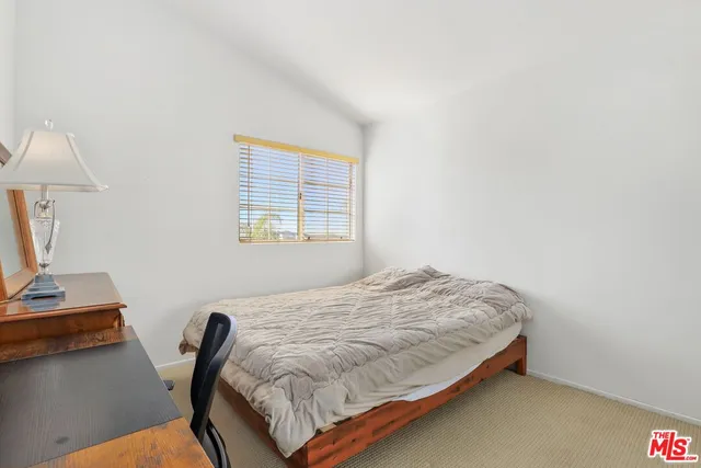 a bedroom with a bed window and a desk