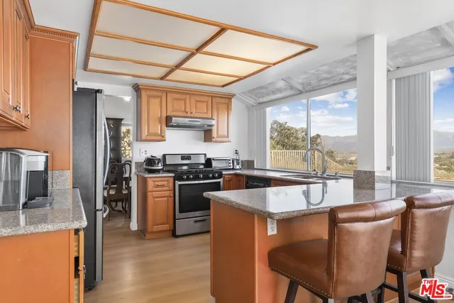 a large kitchen with a table chairs refrigerator and cabinets