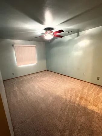 en empty room with windows and fireplace